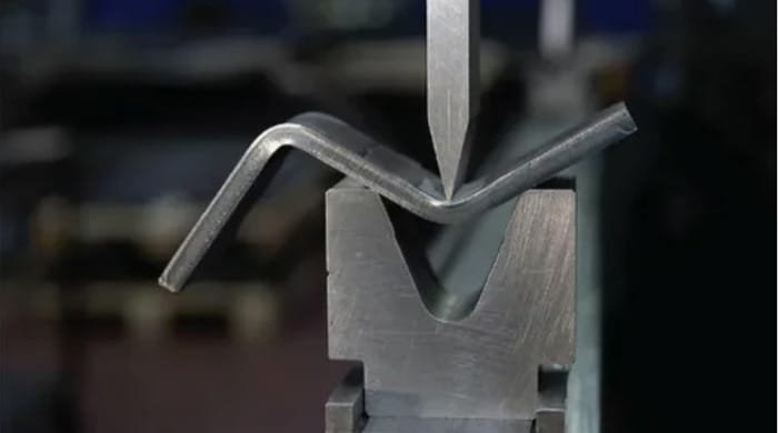 Press brake tooling bending a sheet metal piece to a precise angle