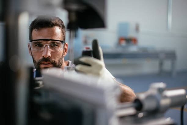 Engineer closely inspecting compression molding equipment in factory